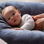 نوزاد در حال دریافت ماساژ ملایم روی کوسن نرم و راحت