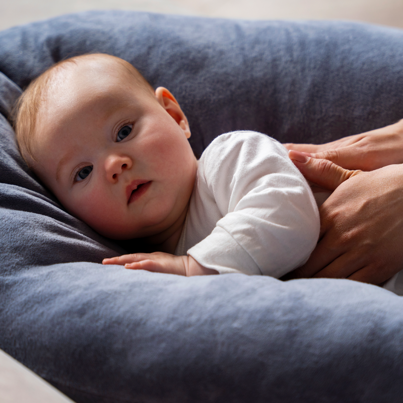 نوزاد در حال دریافت ماساژ ملایم روی کوسن نرم و راحت